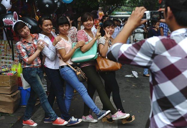 A group of young Vietnamese women poses for a photo at a toy market in Hanoi, Sept. 25, 2012.