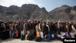 Afghan citizens wait to cross into their home country at the border post in Torkham on March 7.