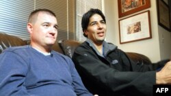 U.S. Army Captain Matt Zeller (left) sits with translator Janis Shenwari, whom he credits for saving his life in a firefight in Afghanistan in November 2008, during an interview in November 2013 in Arlington, Virginia.