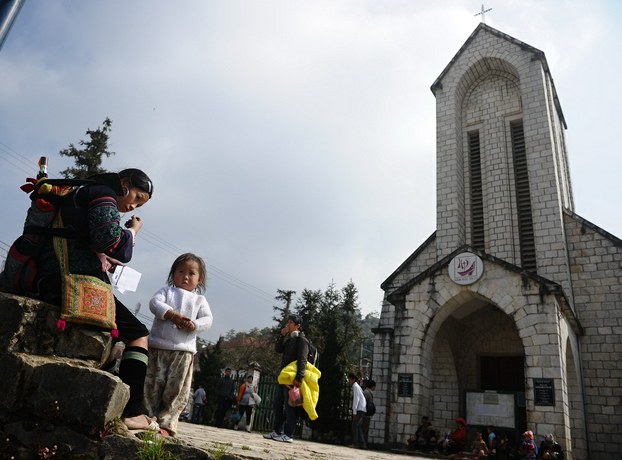 A Hmong woman sells souvenirs in front of a church in Sapa in Vietnam's northern highlands.