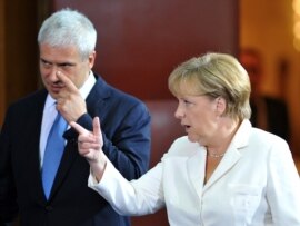 Serbian President Boris Tadic and German Chancellor Angela Merkel arrive at a joint news conference after their meeting in Belgrade.