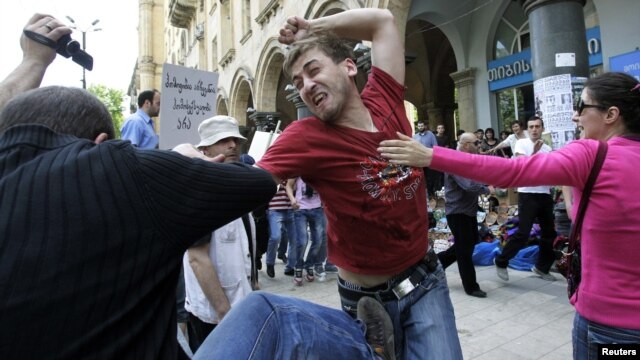 A gay rights activist clashes with an Orthodox Christian activist in Tbilisi on May 17, 2012.