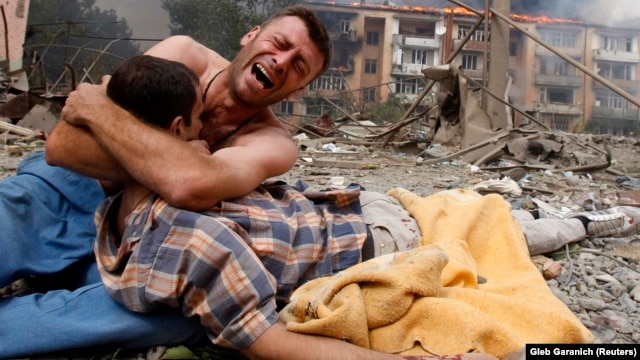 A Georgian man cries as he holds the body of his relative after a bombardment in Gori, 80 kilometers from Tbilisi, in August 2008.