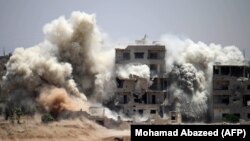 Smoke rises around buildings following a reported air strike on a rebel-held area in the southern Syrian city of Daraa on June 22.