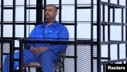 Saif al-Islam Qaddafi, the second son of Libya's late dictator Muammar Qaddafi, attends a hearing behind bars in a courtroom in Zintan, Libya, in 2014.