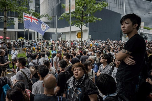 A Hong Kong colonial flag is seen waved by a demonstrator during a protest against plans for a new town development outside the government headquarters in Hong Kong, June 20, 2014.