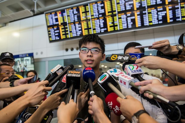 Hong Kong democracy campaigner Joshua Wong (C) speaks to the media upon his arrival at the international airport in Hong Kong, after being deported from junta-run Thailand, Oct. 5, 2016.