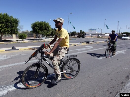 Libyan National Transitional Council fighters ride on bicycles to get to the front line in the center of Sirte on October 12.