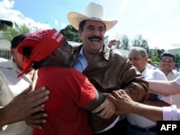 Supporters cheer and greet ousted Honduran President Manuel Zelaya (center) as he arrives at the Brazilian Embassy in Tegucigalpa on September 21.