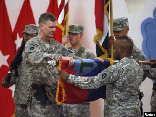 U.S. military personnel fold their unit flag during a ceremony marking the withdrawal of 1,000 U.S. soldiers from a military base at the Al-Basrah airport in September.
