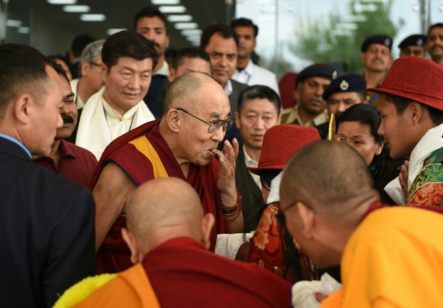 Tibetan spiritual leader the Dalai Lama gestures as he is greeted by well-wishers at Kangra Airport in Dharamsala, India, March 13, 2016.