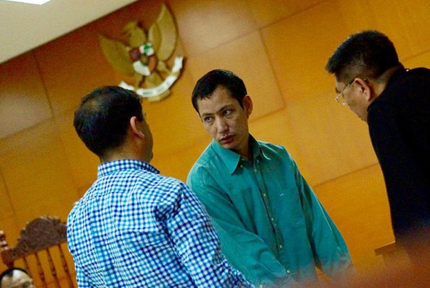 Nur Muhammet Abdullah (center) speaks to his attorney after being sentenced to six years in East Jakarta District Court, Nov. 2, 2016.