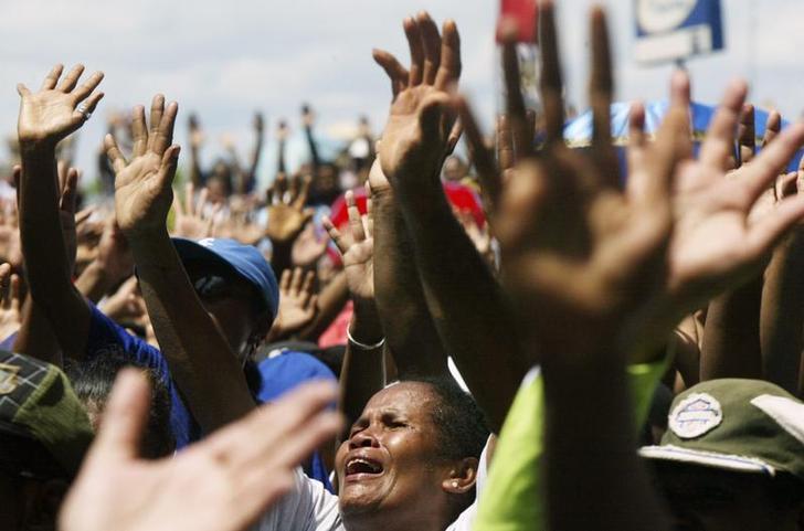 Christian Papuans sing a religious song during a protest in Jayapura of the Indonesia Papua province August 5, 2008. About 1,000 Papuans rallied against Indonesian government's plan to implement Islamic sharia law in the Christian stronghold.