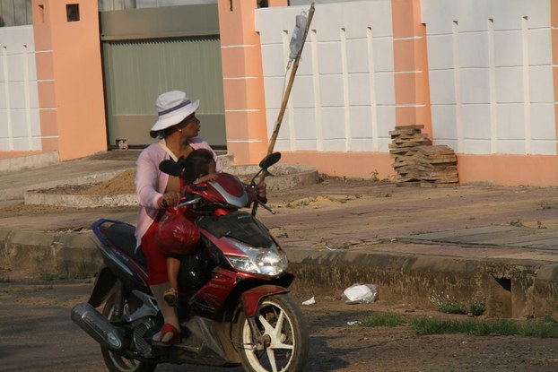 A Villager drives her daughter on a motorbike to seek medical attention in Sre Cha commune, March 10, 2015.