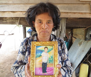 Moeun Mat's grandmother holds a picture of the young victim at the family's home in Banteay Meanchey province, Dec. 6, 2012.