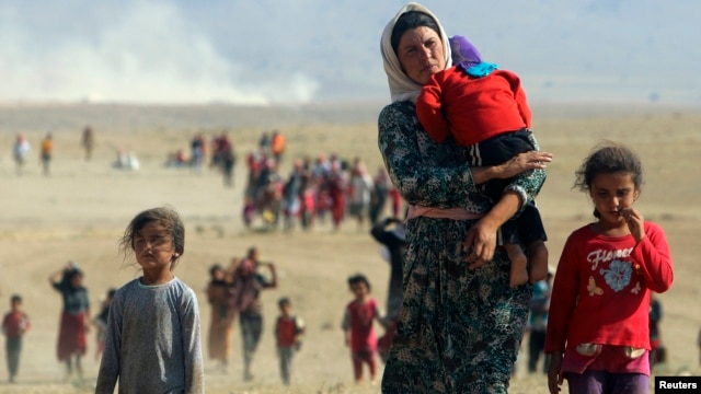 Displaced people from the minority Yazidi sect, flee violence from Islamic State (IS) militants in the town of Sinjar in northern Iraq in August 2014.