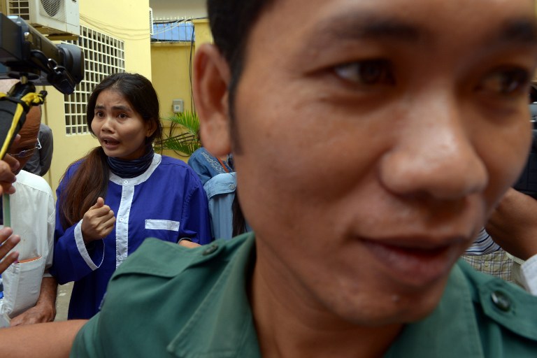 Cambodian land activist Yorm Bopha (L) is escorted by a prison guard upon her arrival at court in Phnom Penh, Nov. 22, 2013.
