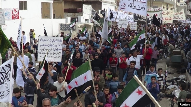 Demonstrators hold opposition flags during a protest against Syria's President Bashar al-Assad, after Friday prayers in Binsh near Idlib on November 2.
