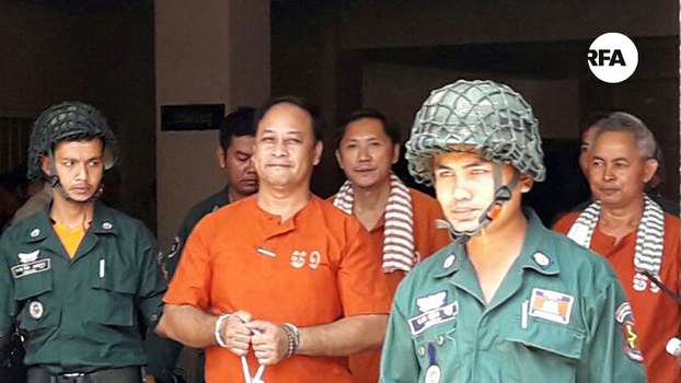 (From L-R in orange) ADHOC workers Nay Vanda, Ny Sokha and Yi Soksan are escorted from Phnom Penh Municipal Court, April 27, 2017.