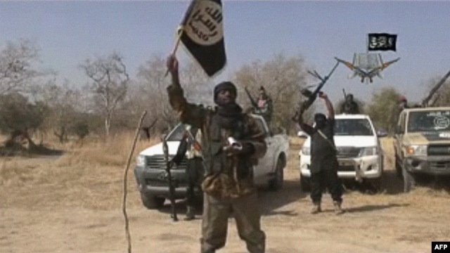 A video grab shows the leader of the Islamist extremist group Boko Haram, Abubakar Shekau, holding up a flag as he delivers a message.