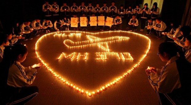 Chinese students in Zhejiang province hold candles to pray for missing passengers of flight MH370, March 10, 2014.