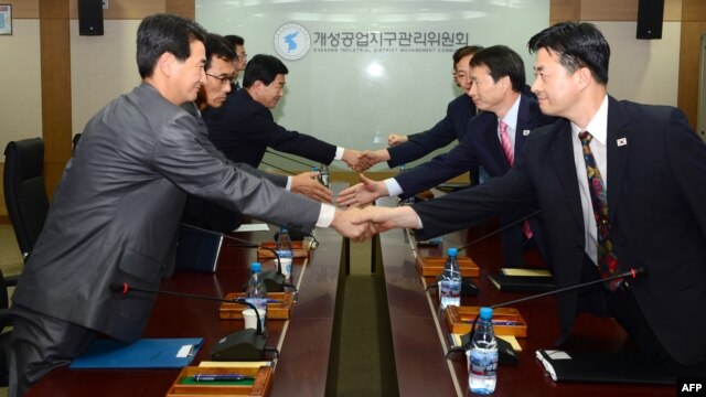 North and South Korean delegates shake hands during a meeting at the Kaesong industrial complex on September 11.