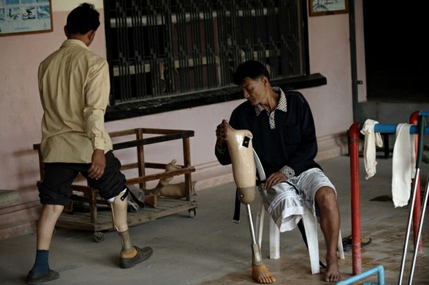 Disabled men seek treatment at a physical rehabilitation center for victims of landmines and road accidents outside Phnom Penh in a file photo.