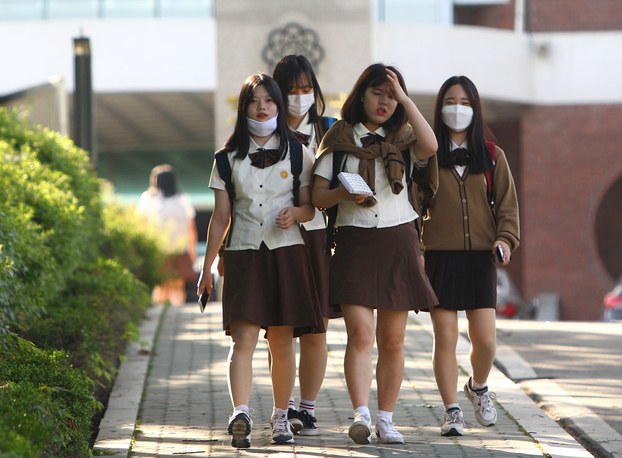 Girls wearing face masks walk homes after school in Pyeongtaek, South Korea, June 3, 2015.