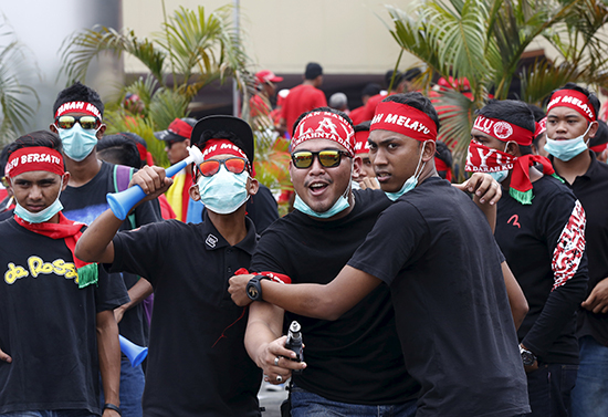 Members of the pro-government "red shirt" group, shown here in a September 16, 2015, file photo, protested outside news website Malaysiakini's office in Kuala Lumpur on November 5. The group's leader had threatened to "tear down" its office two days prior. (Reuters/Olivia Harris)