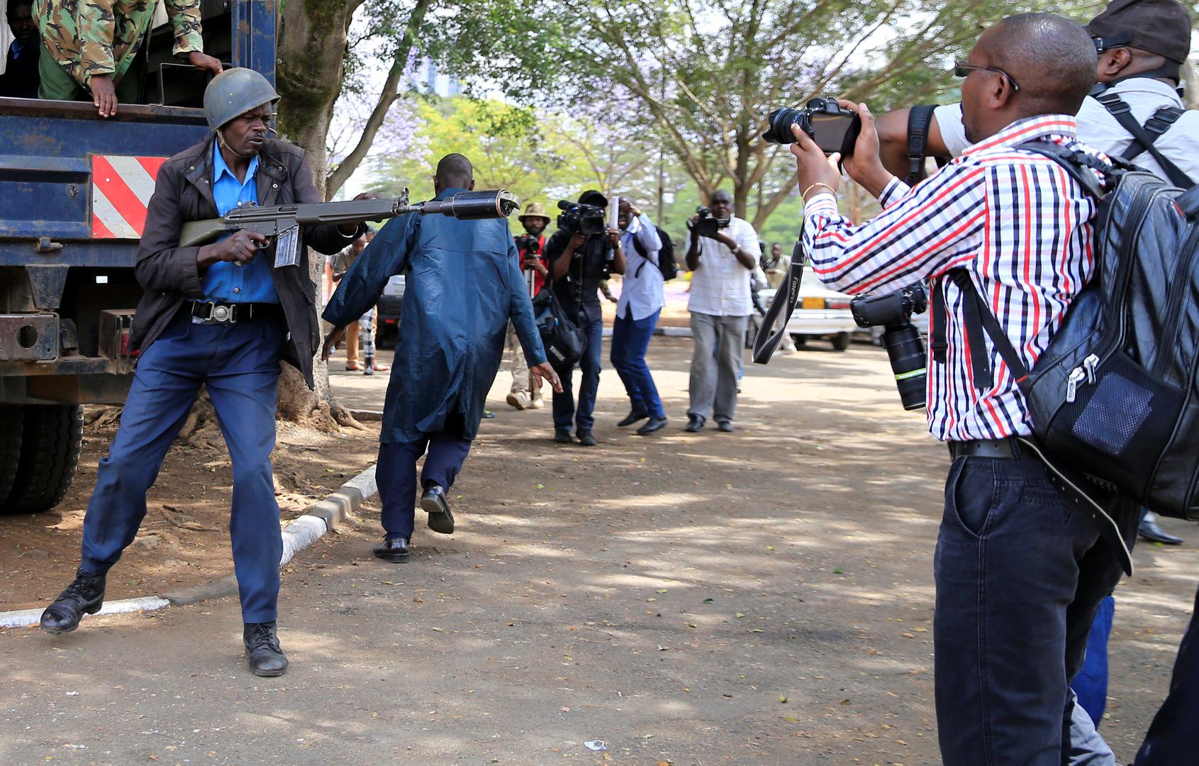 An anti-riot police officer aims a teargas canister while journalists cover an anti-corruption protest in Kenya's capital, Nairobi. November 3, 2016.