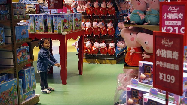 A child reacts to Peppa Pig toys on display at the British Hamley's toy store in Beijing, May 2, 2018.