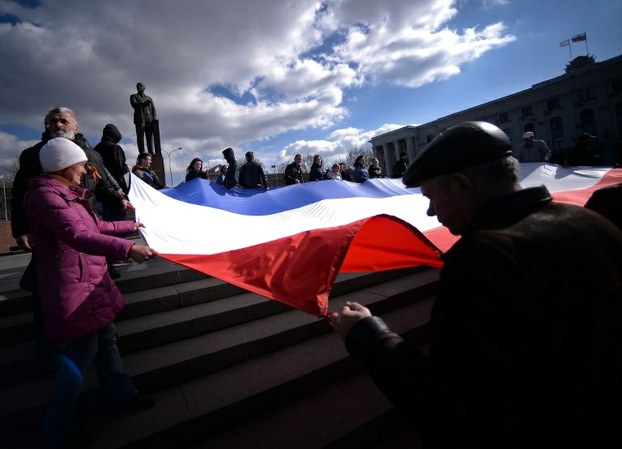 Demonstrators hold a Crimean flag at Lenin's square in central Simferopol in Crimea on March 18, 2014.