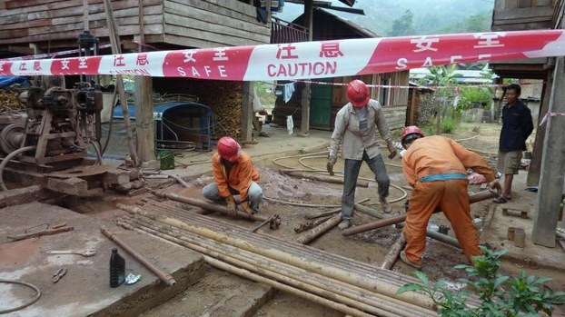 Chinese workers drill for soil analyses as part of railway construction preparations in Bopiat village in northern Laos's Luang Namtha province, March 11, 2011.