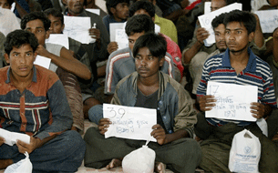 Rohingya migrants sit outside the Ranong police station before being transported to Thai police immigration in Thailand's southern Ranong province, Jan. 31, 2009.