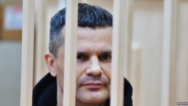 Domodedovo Airport owner Dmitry Kamenshchik looks out from a defendants cage during a court hearing in Moscow on February 19.