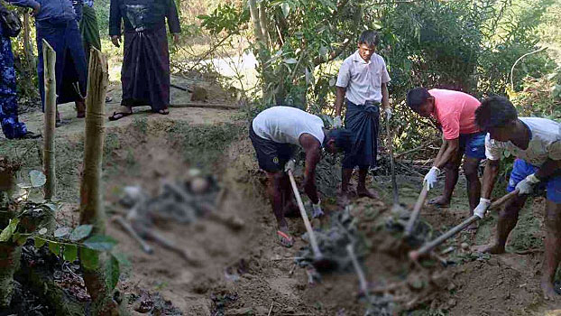 Myanmar laborers dig up the remains of unidentified bodies from a mass grave where soldiers buried Rohingya Muslims they killed in Inn Din village, Maungdaw township, western Myanmar's Rakhine state, Dec. 19. 2017.