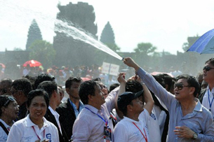Thaksin Shinawatra sprays water towards supporters in front of Angkor Wat temple in Siem Reap, April 15, 2012.