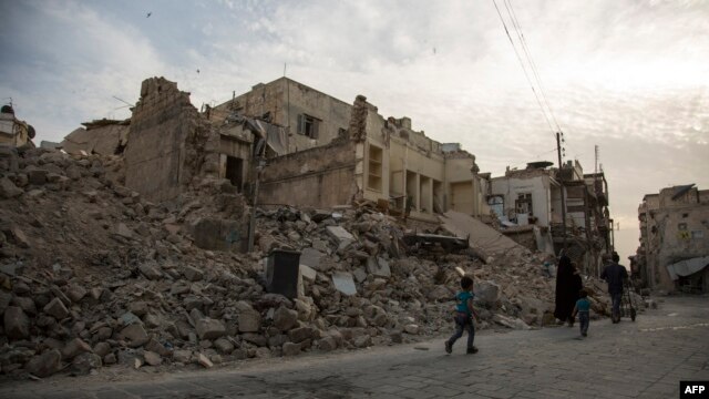 A Syrian family walks past destroyed buildings in the northern city of Aleppo on May 2.