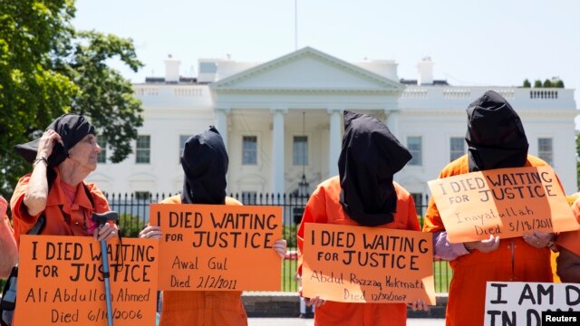 Activists wearing orange jumpsuits mark the 100th day of a prisoners' hunger strike at Guantanamo Bay during a protest in May in front of the White House in Washington, D.C.