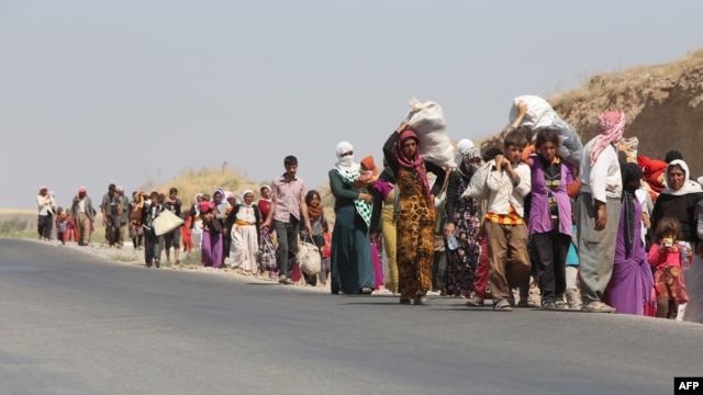 Displaced Iraqi families from the Yazidi community cross the Iraqi-Syrian border at the Fishkhabur crossing, in northern Iraq, on August 13.