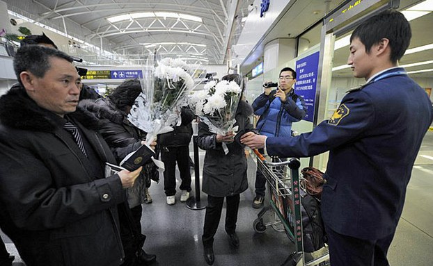 A Chinese airport security guard (R) checks the passports of North Koreans entering China at Beijing Capital International Airport in a file photo.