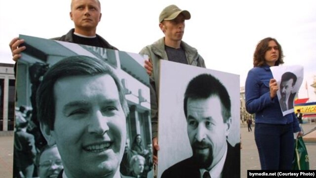 Protesters hold pictures of Belarusian opposition politician Viktar Hanchar (left) and businessman Anatol Krasouski. Both men have been missing since 1999. (file photo)