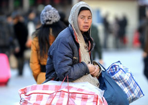 A Chinese woman prepares to take the train at the Beijing railway station ahead of the Lunar New Year, Feb. 4 , 2013.