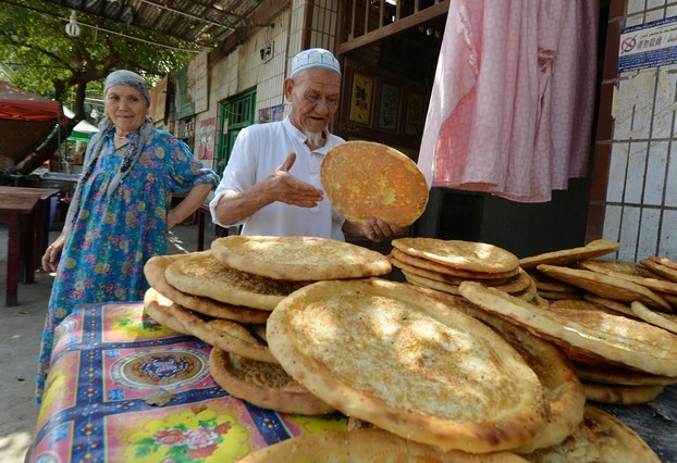 Uyghurs display bread at their stall in Lukqun, Xinjiang Uyghur Autonomous Region, June 27, 2013.