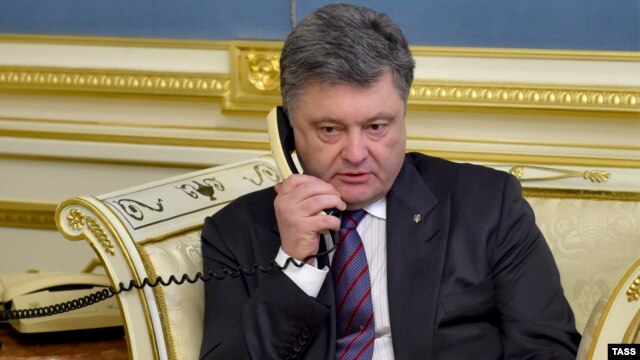 Ukrainian President Petro Poroshenko talks to Nadia Savchenko by phone at the presidential office in Kyiv on April 19.