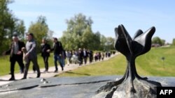 Members of Croatia's Jewish community walk past a memorial in the shape of a flower at Jasenovac in April 2016.
