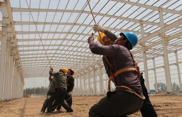 Chinese workers labor at the construction site of an industry park in Wenxian county, Jiaozuo city, central Henan province, May 1, 2013.