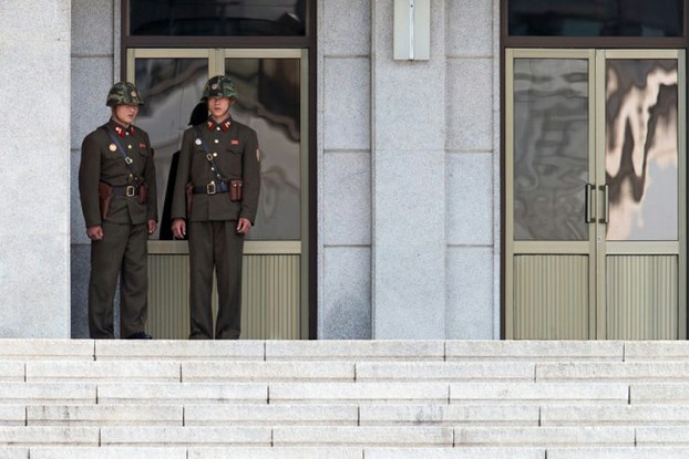 North Korean border guards stand outside a building in the truce village of Panmunjom in the Demilitarized Zone dividing the two Koreas, Sept. 25, 2013.