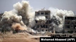Smoke rises around buildings following a reported air strike on a rebel-held area in the southern Syrian city of Daraa on June 22.