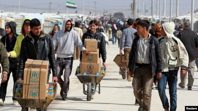 Syrian refugees in Jordan collect aid and rations at the Al-Zaatri refugee camp in the city of Mafraq near the border with Syria on March 6.
